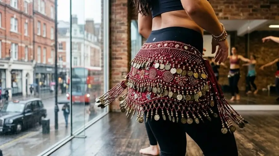 Close-up of a beaded belly dance hip scarf worn during a class in London