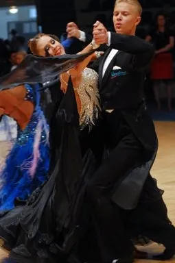 A couple dancing quickstep in ballroom competition hold
