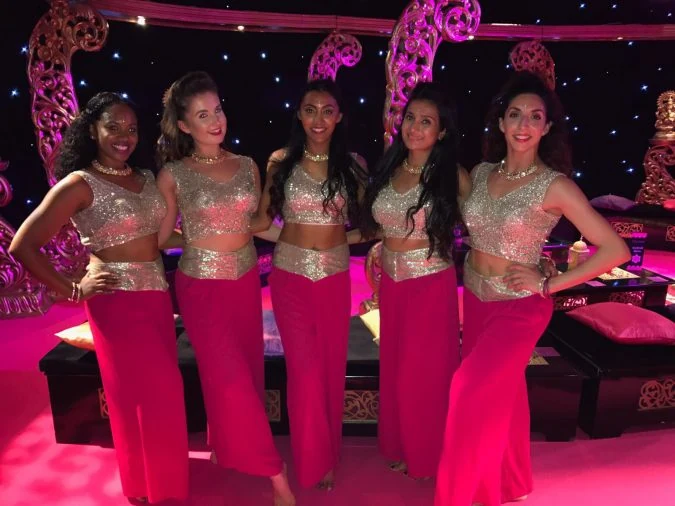 Five dancers in traditional attire posing together