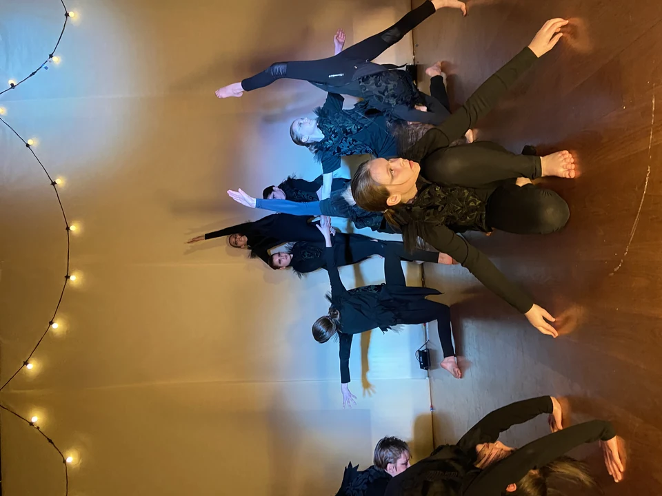 Group of dancers in black outfits performing contemporary dance