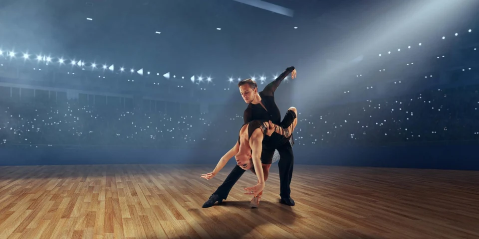 Couple dancing on stage with dramatic lighting