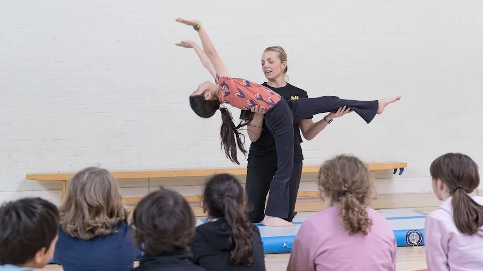 Dance instructor assisting a student in a class