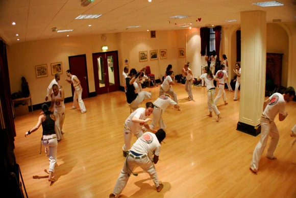 Group of people practicing Capoeira in a studio