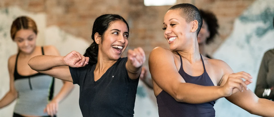 Two women dancing joyfully in a studio