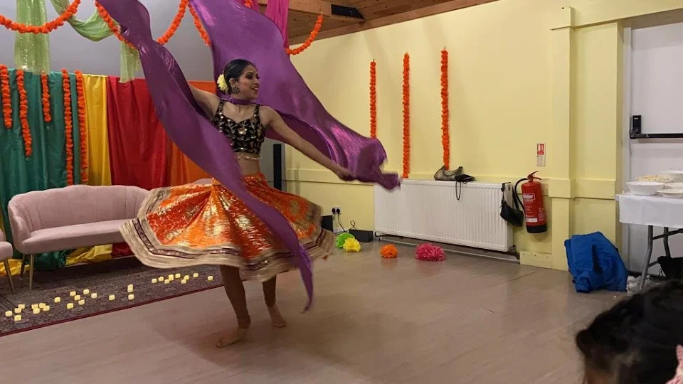 Woman performing dance with colorful attire and props