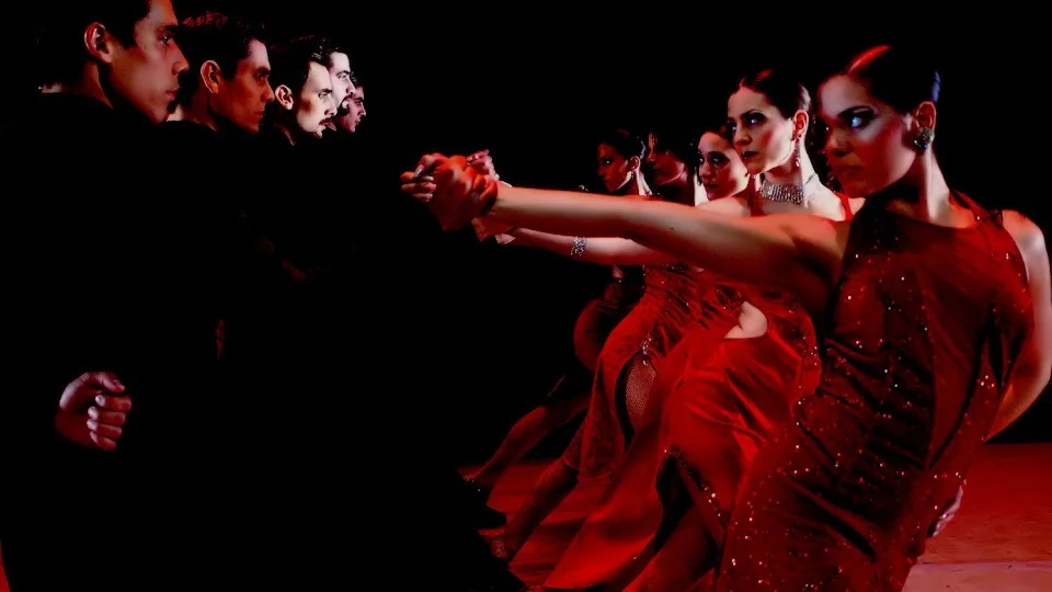 Group of dancers in red dresses performing tango