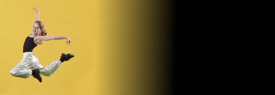 Dancer performing a leap against a yellow background