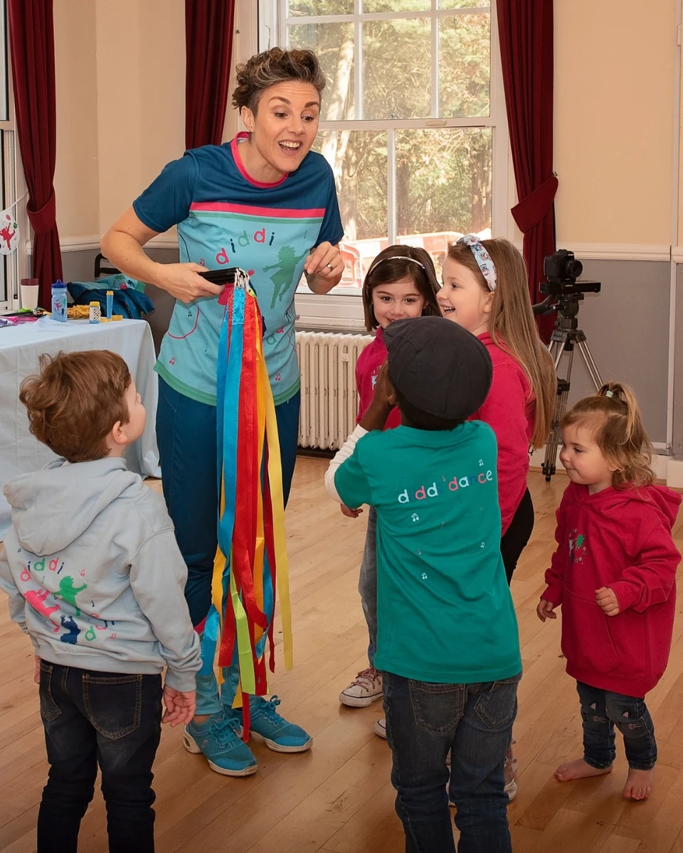 Children participating in a dance class with ribbons