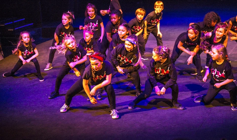 Group of children performing dance on stage