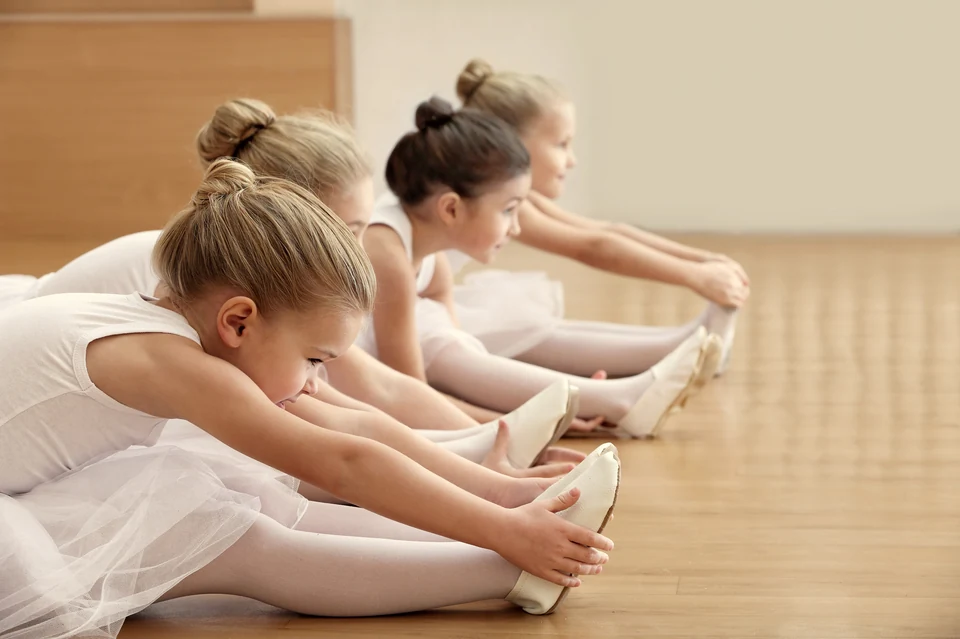 Young ballet dancers stretching in a studio
