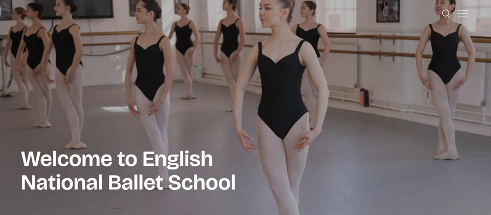 Dancers in black leotards practicing ballet in a studio