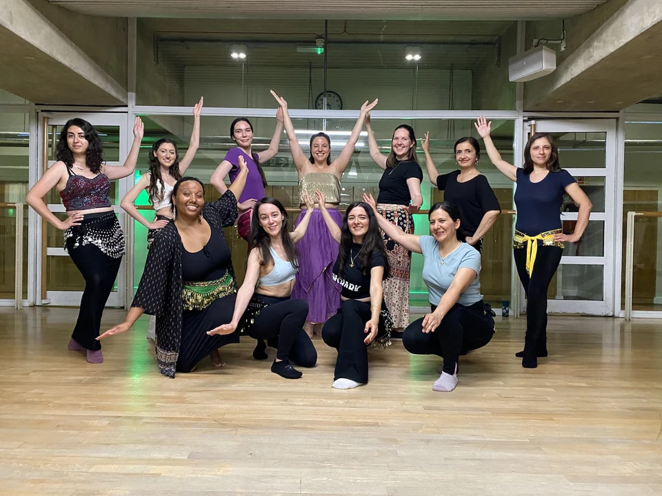 Group of women performing belly dance in a studio