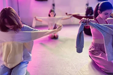 Dancers practicing with clothing in a studio setting