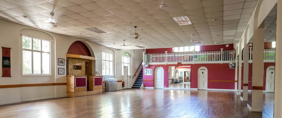 Dance studio interior with wooden floor and red walls