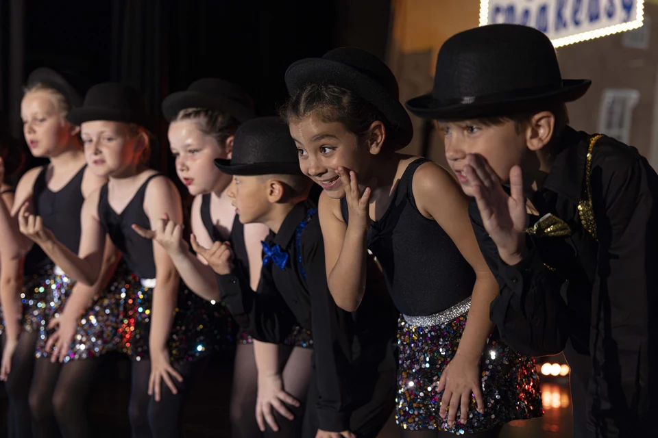 Children performing in dance costumes on stage