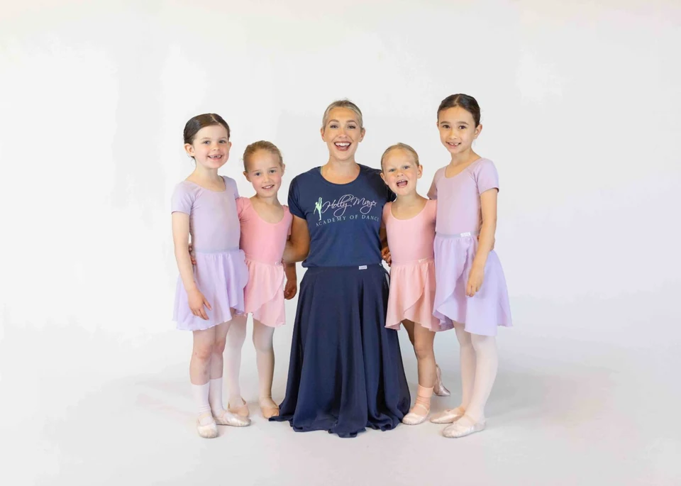 Group of ballet dancers with instructor in studio