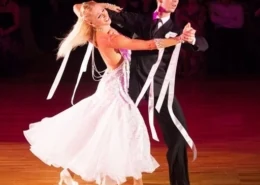 Couple dancing in formal attire with ribbons