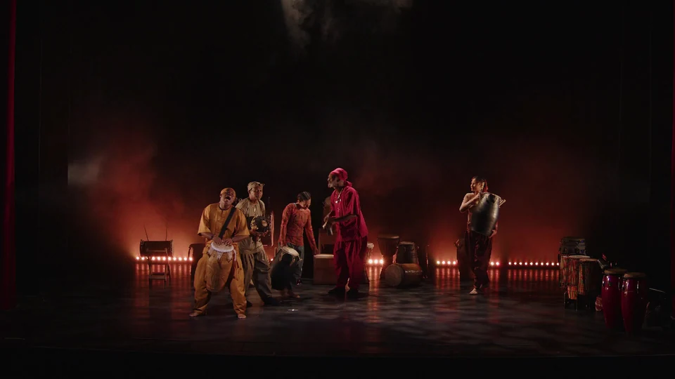 Performers on stage with drums and instruments