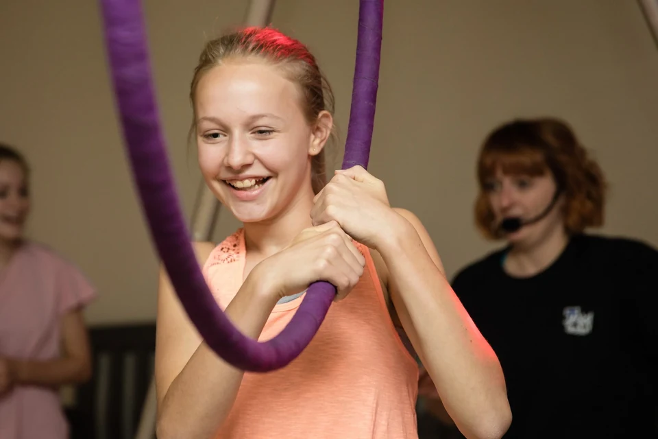 Girl smiling while holding aerial silks