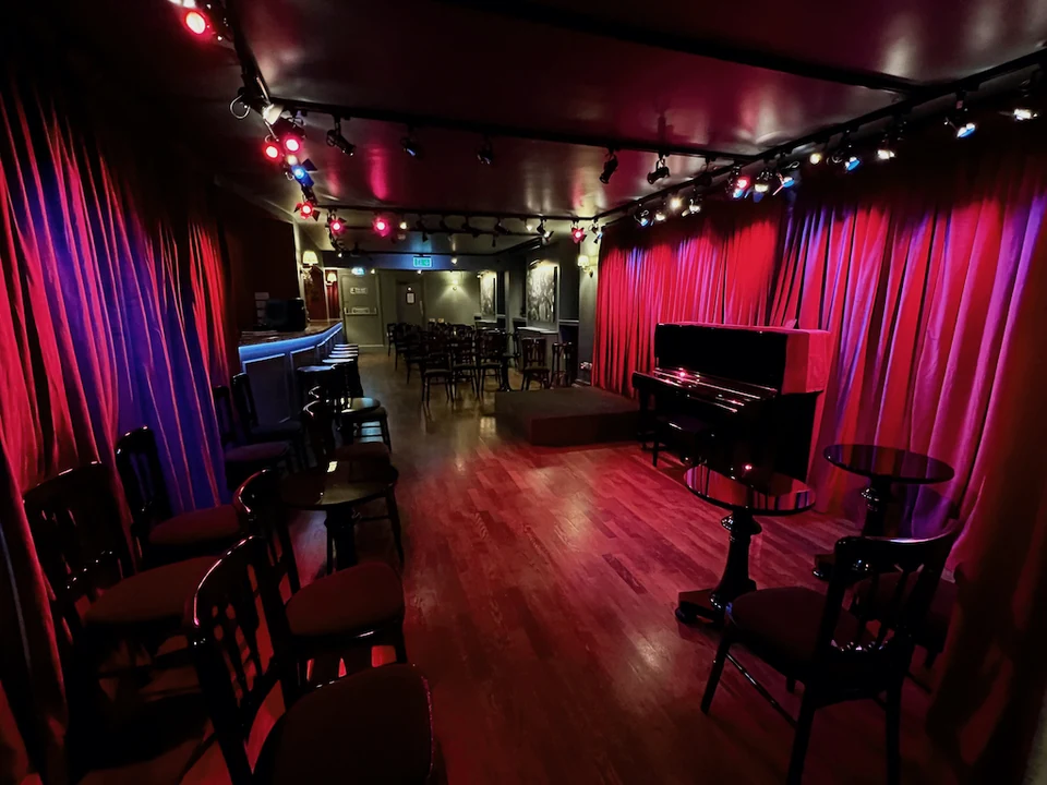 Intimate dance venue with red curtains and seating