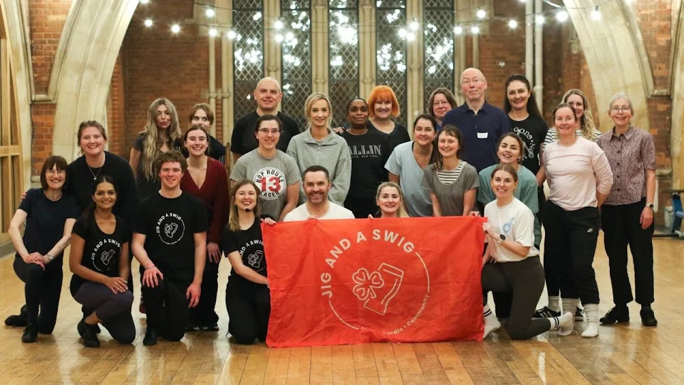 Group photo of dancers holding a red banner