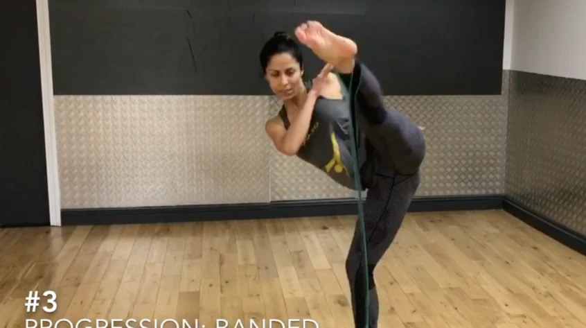 Person demonstrating a Capoeira kick in a studio