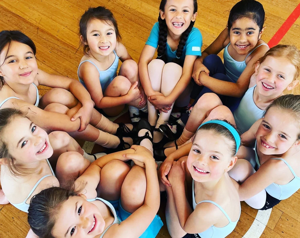 Group of young dancers sitting in a circle