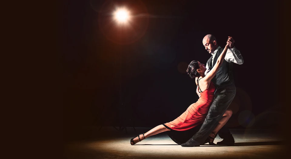 Couple dancing tango in a spotlight