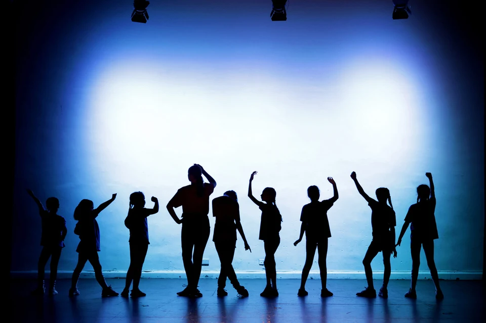 Silhouettes of dancers in a studio setting