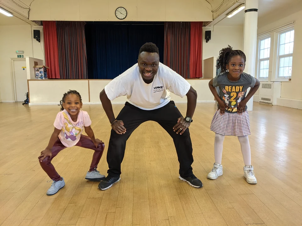 Two children and an instructor in a dance studio