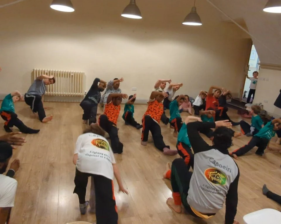 Group of people practicing Capoeira indoors