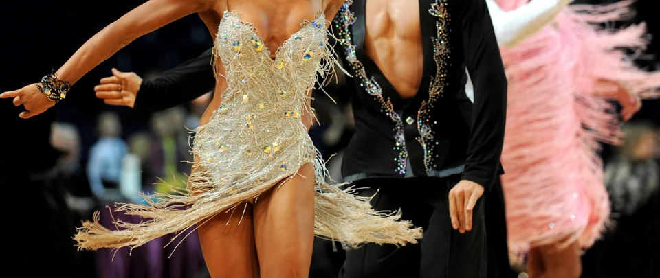 Couple dancing in colorful costumes at a competition