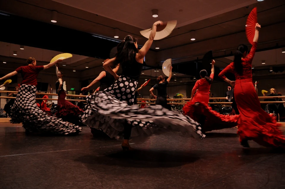 Dancers performing Flamenco with fans in a studio