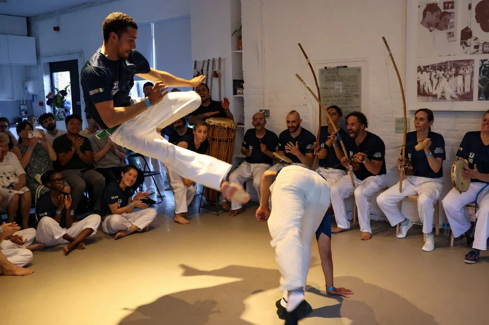 Capoeira performance with audience in a dance studio