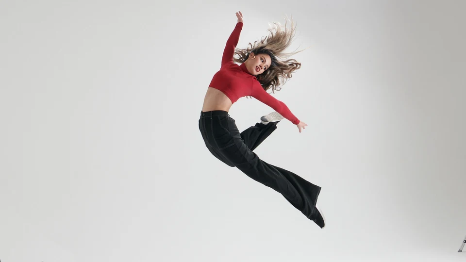 Dancer performing a leap in a studio setting