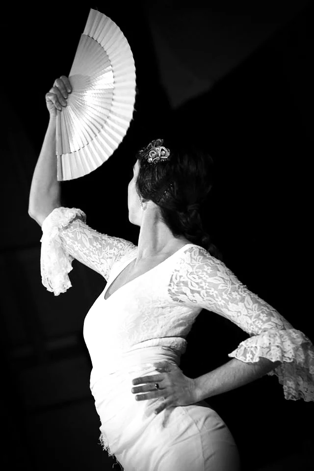Dancer holding a fan in a flamenco pose