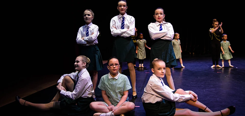 Group of dancers in performance attire on stage