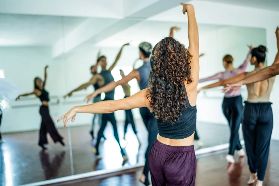 Dancers practicing in a mirrored studio space