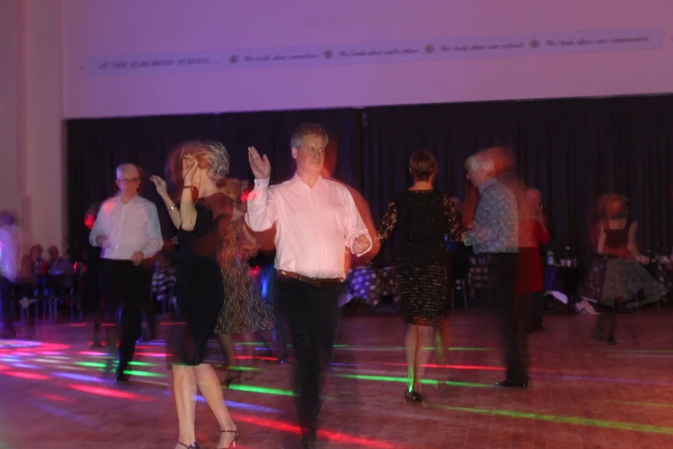 People dancing in a dimly lit hall