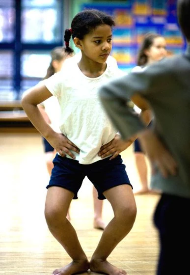 Child practicing dance in a studio setting