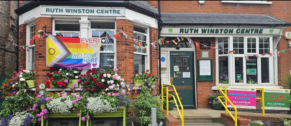 Exterior of Ruth Winston Centre with flowers and banners