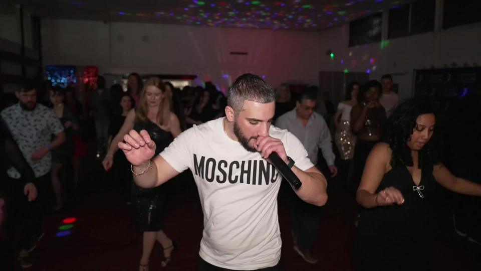 People dancing at a salsa event with a performer
