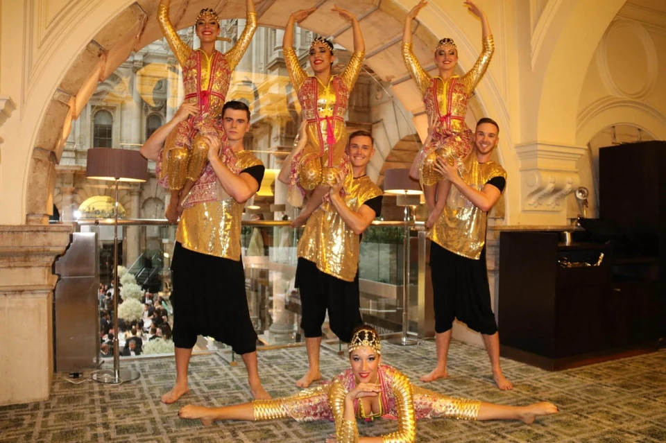 Group of dancers in colorful costumes performing indoors