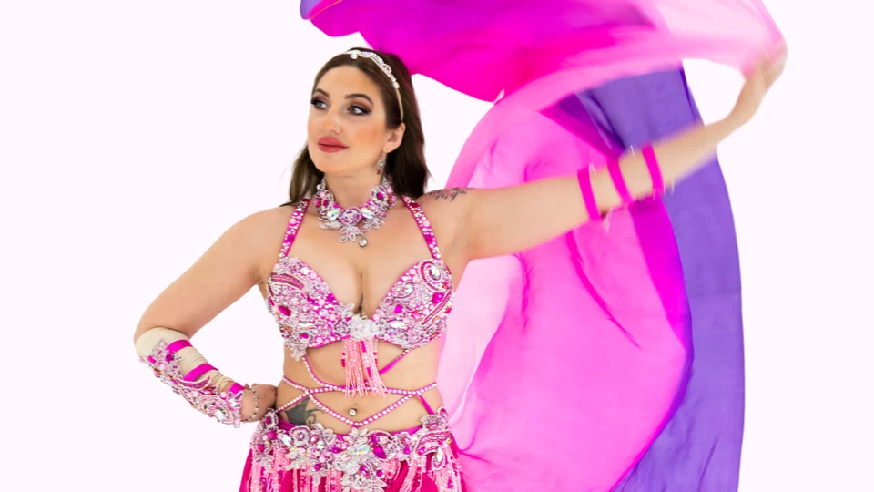 Belly dancer in pink costume with flowing fabric