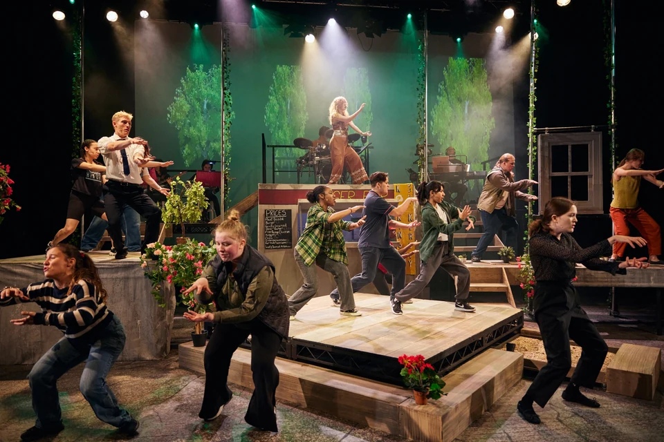 Group of dancers performing on stage with props