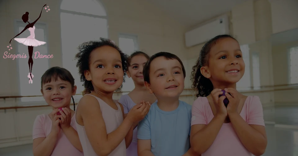 Children in dance attire smiling in a studio