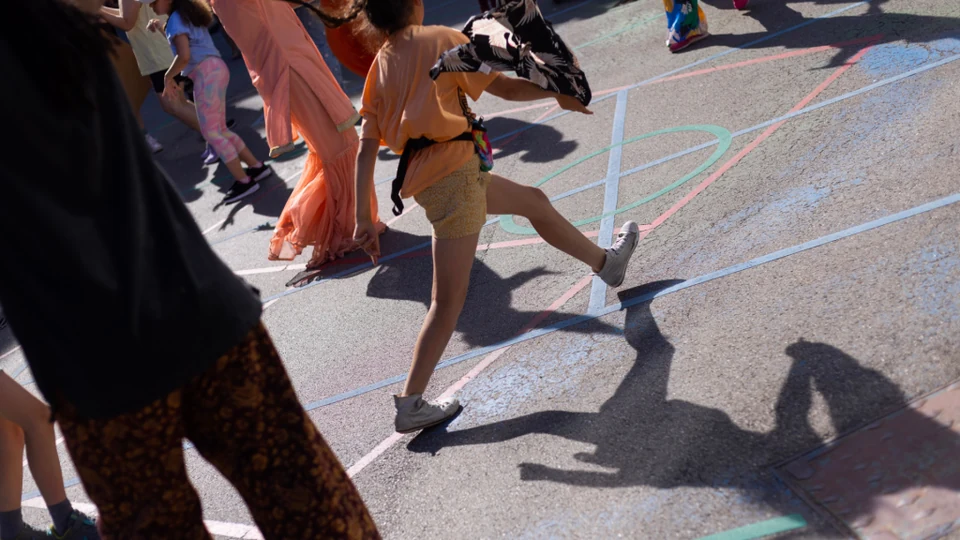 Children dancing on a colorful outdoor surface