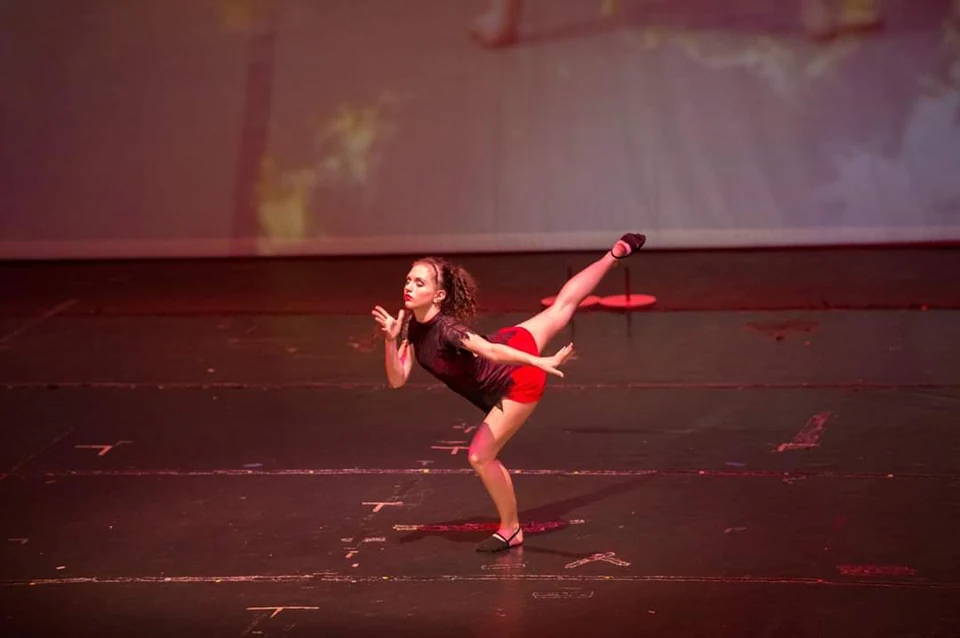 Dancer performing on stage with dramatic lighting