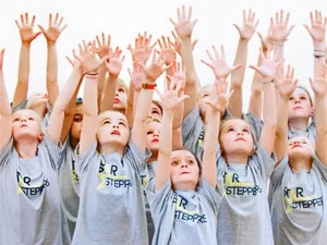 Children with raised hands in dance attire