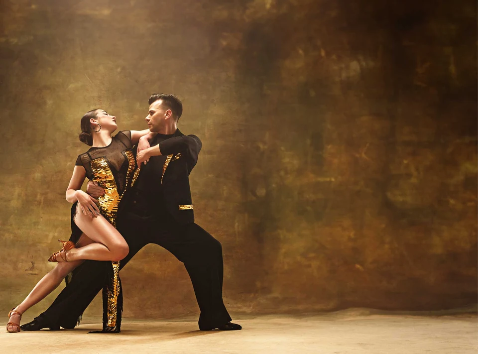 Couple dancing in elegant attire against a textured background